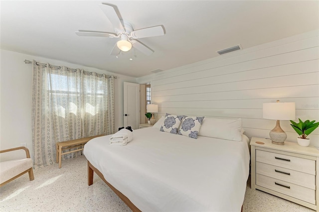 bedroom with visible vents, light speckled floor, and ceiling fan