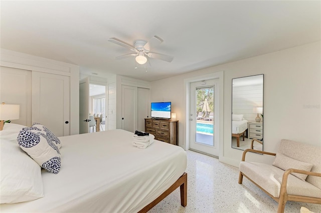 bedroom featuring ceiling fan, multiple closets, light speckled floor, and access to exterior