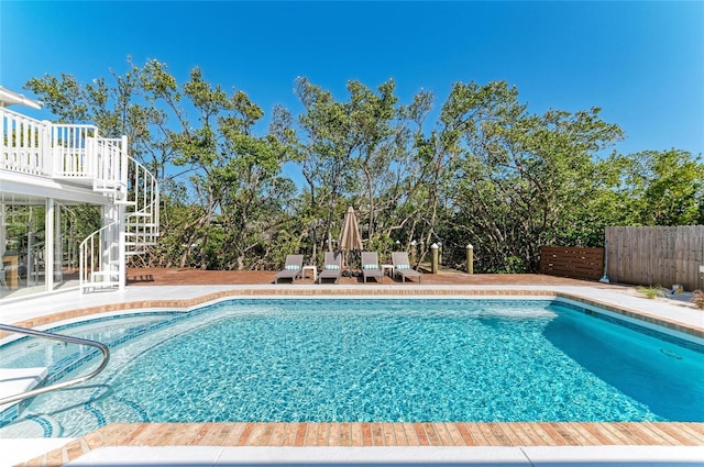 view of pool featuring a patio, fence, a fenced in pool, a wooden deck, and stairs