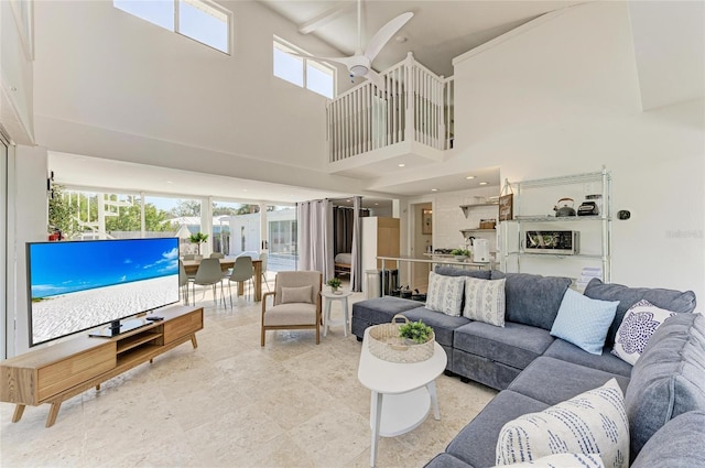 living area featuring a high ceiling and ceiling fan