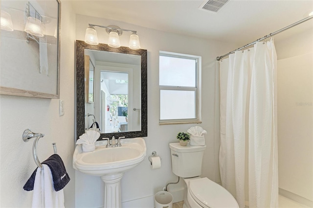 full bathroom featuring visible vents, toilet, and a shower with shower curtain