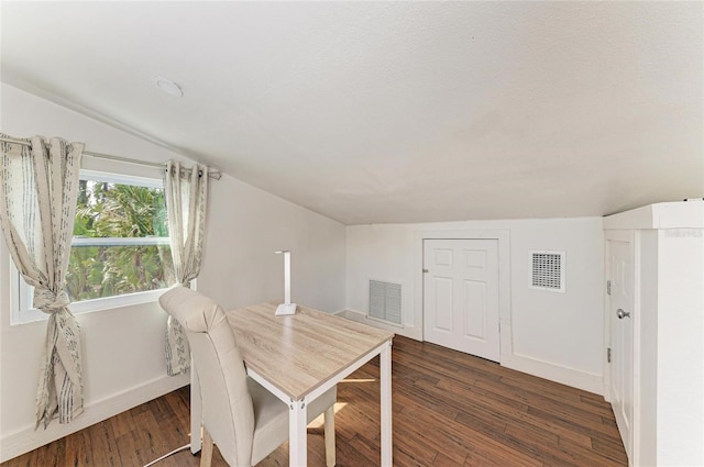dining area featuring dark wood finished floors, lofted ceiling, baseboards, and visible vents