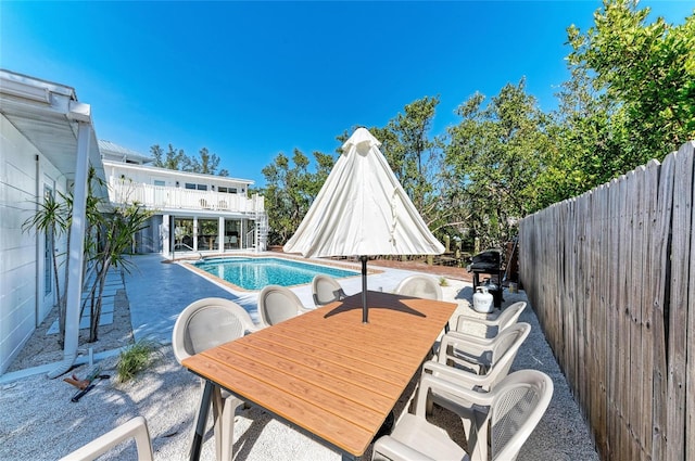 view of swimming pool featuring a fenced backyard, a fenced in pool, outdoor dining area, and a patio