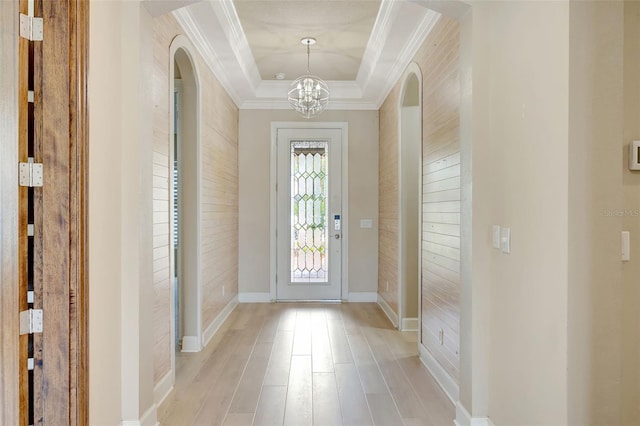 12711 Del Corso Loop, Bradenton, FL 34211 - entrance foyer with crown molding, a chandelier, arched walkways, light wood-style flooring, and a tray ceiling