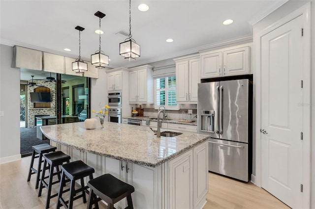12711 Del Corso Loop, Bradenton, FL 34211 - kitchen with appliances with stainless steel finishes, ceiling fan, recessed lighting, light wood finished floors, and ornamental molding