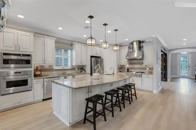 12711 Del Corso Loop, Bradenton, FL 34211 - kitchen with wall chimney exhaust hood, appliances with stainless steel finishes, plenty of natural light, a breakfast bar area, and crown molding