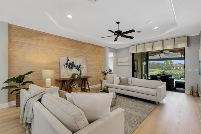 12711 Del Corso Loop, Bradenton, FL 34211 - living room with a tray ceiling, a ceiling fan, wood walls, recessed lighting, and light wood-style floors