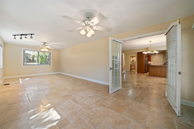 spare room with stone tile floors and baseboards