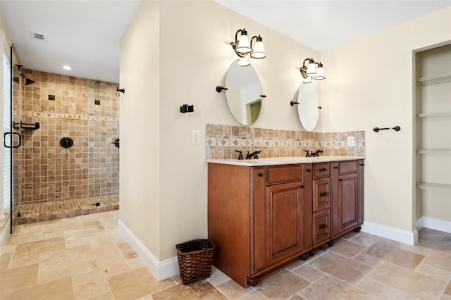 bathroom featuring double vanity, tasteful backsplash, a shower stall, and visible vents
