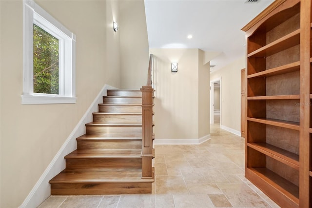 stairs with baseboards and stone finish floor