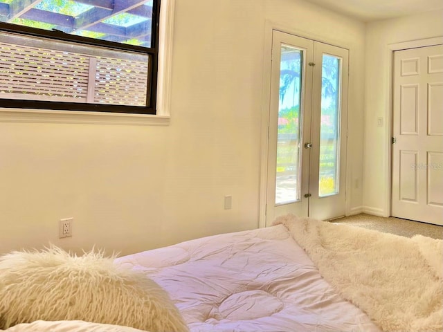 carpeted bedroom with access to exterior and french doors