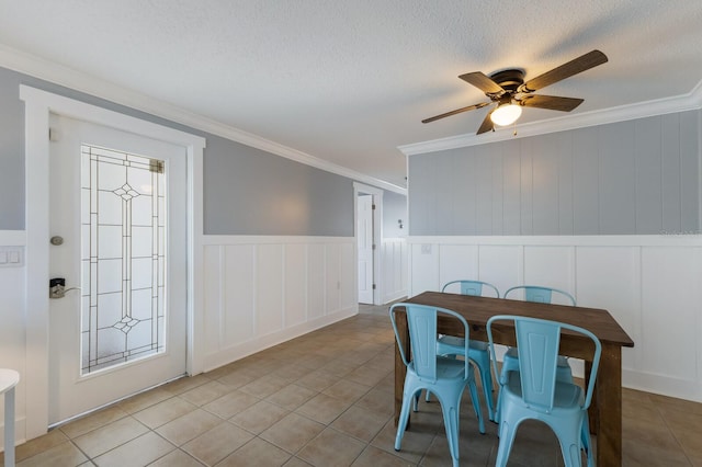 dining room featuring a textured ceiling, ceiling fan, tile patterned flooring, and crown molding