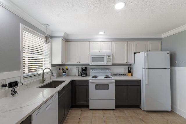 kitchen with light tile patterned flooring, a sink, a textured ceiling, white appliances, and ornamental molding