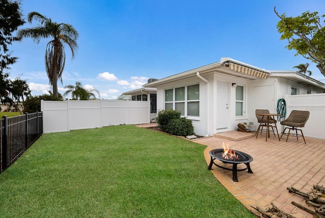 view of yard featuring an outdoor fire pit, a fenced backyard, and a patio area
