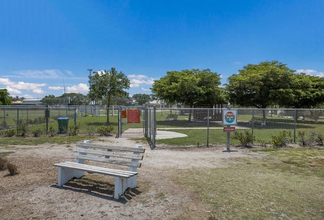 surrounding community featuring a gate, fence, and a lawn