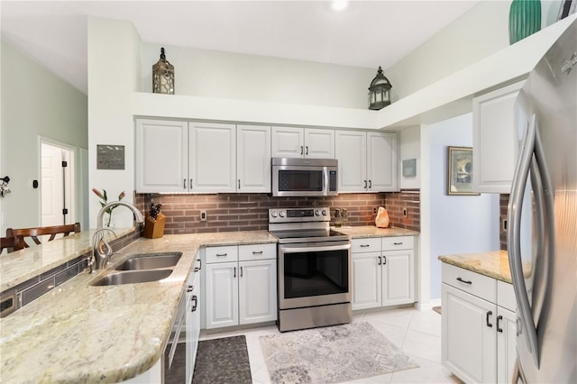 1118 Deardon Dr, Venice, FL 34292 - kitchen featuring decorative backsplash, a peninsula, appliances with stainless steel finishes, a sink, and light stone counters