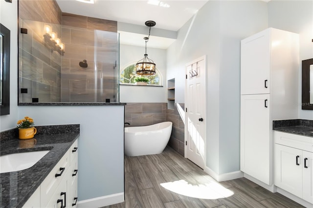 1118 Deardon Dr, Venice, FL 34292 - full bath featuring tile walls, a chandelier, a soaking tub, two vanities, and a walk in shower