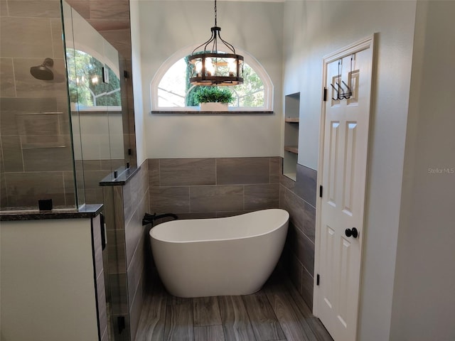 1118 Deardon Dr, Venice, FL 34292 - bathroom with tile walls, wood finished floors, a soaking tub, and walk in shower