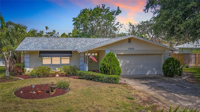 ranch-style home featuring concrete driveway, a garage, and stucco siding