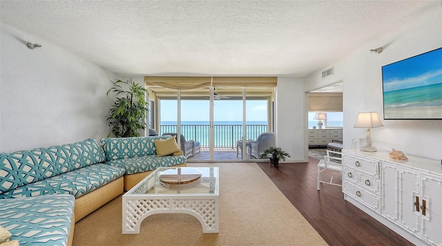 2675 Gulf Of Mexico Dr Unit 403, Longboat Key, FL 34228 - living area with a water view, dark wood finished floors, a textured ceiling, and visible vents