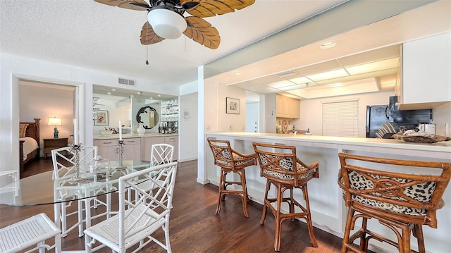 2675 Gulf Of Mexico Dr Unit 403, Longboat Key, FL 34228 - kitchen featuring ceiling fan, a kitchen breakfast bar, visible vents, light countertops, and dark wood-type flooring