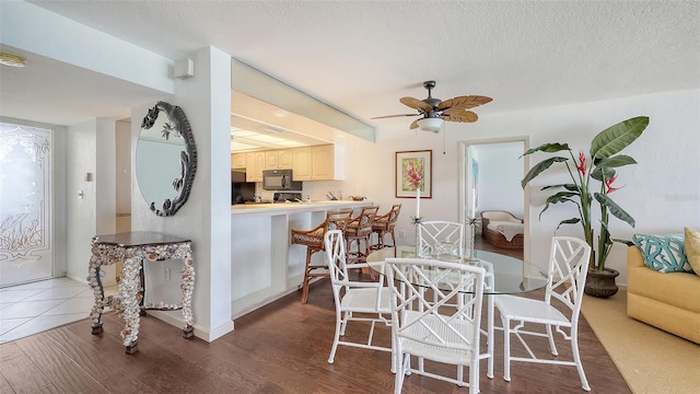 2675 Gulf Of Mexico Dr Unit 403, Longboat Key, FL 34228 - dining room with a ceiling fan, a textured ceiling, and wood finished floors