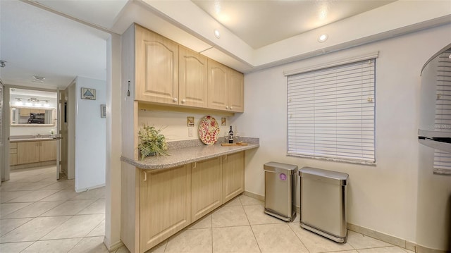 2675 Gulf Of Mexico Dr Unit 403, Longboat Key, FL 34228 - kitchen with light tile patterned floors, light brown cabinets, baseboards, and a sink
