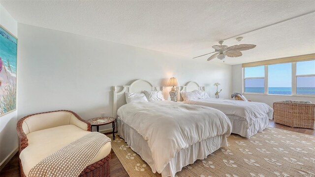 2675 Gulf Of Mexico Dr Unit 403, Longboat Key, FL 34228 - bedroom featuring a water view, a textured ceiling, ceiling fan, and light wood-style floors