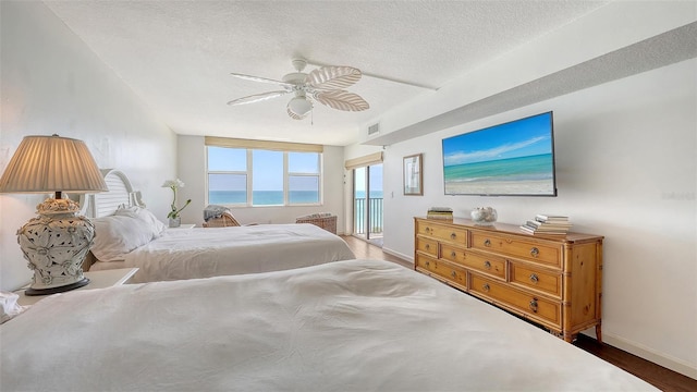 2675 Gulf Of Mexico Dr Unit 403, Longboat Key, FL 34228 - bedroom featuring ceiling fan, a textured ceiling, visible vents, wood finished floors, and baseboards