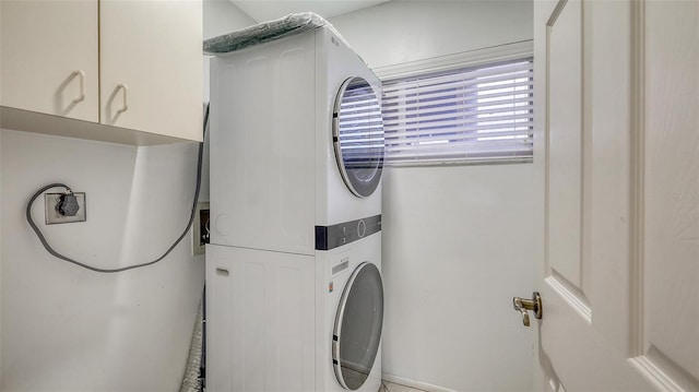 2675 Gulf Of Mexico Dr Unit 403, Longboat Key, FL 34228 - clothes washing area with stacked washer / drying machine and cabinet space