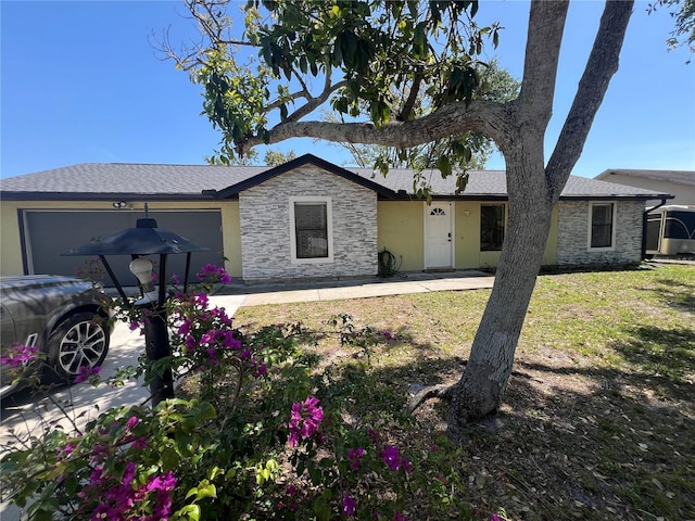 ranch-style home featuring a front yard, stucco siding, stone siding, and a garage