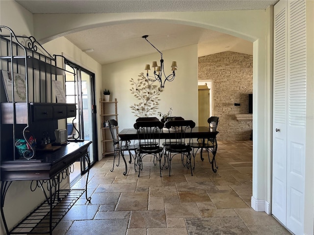 dining area with arched walkways, lofted ceiling, a notable chandelier, and stone tile flooring