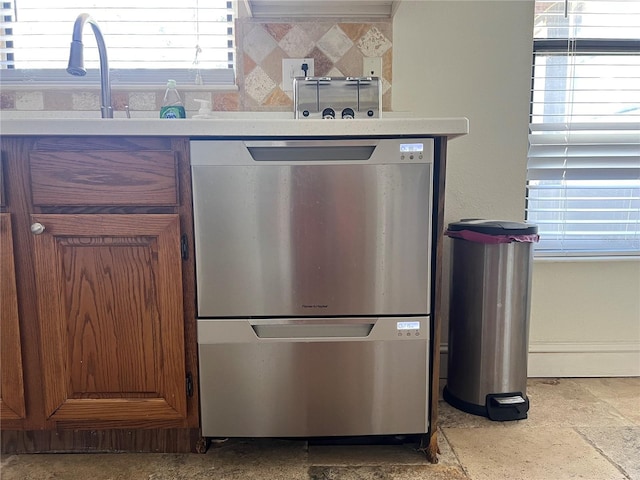 kitchen with tasteful backsplash, light countertops, and dishwasher