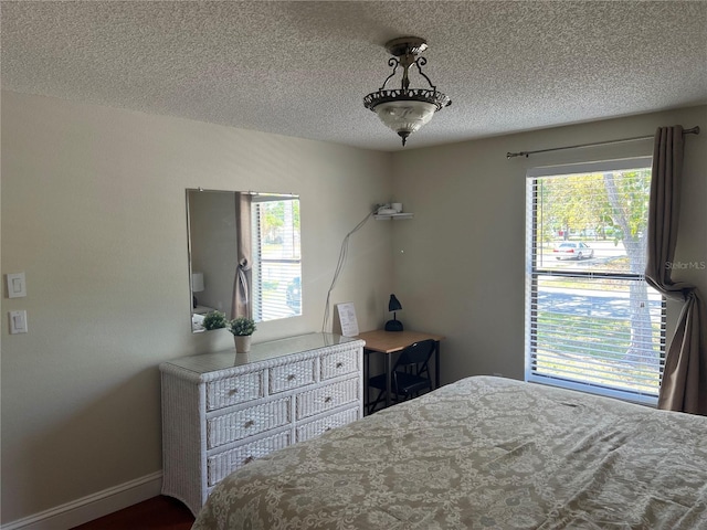 bedroom featuring baseboards and a textured ceiling