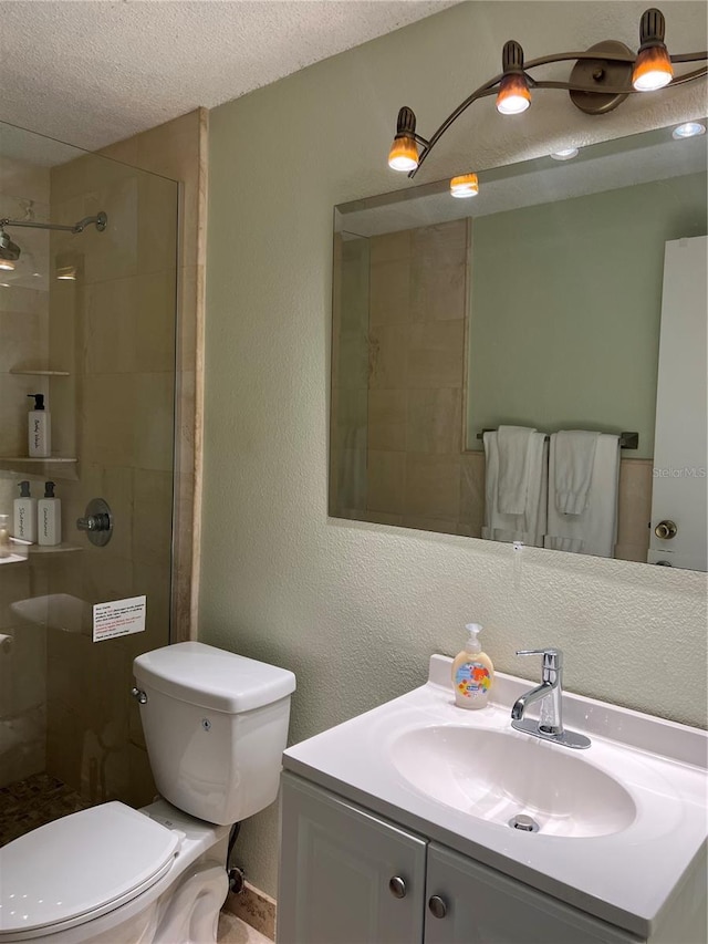 full bathroom with toilet, vanity, a textured ceiling, and a shower stall