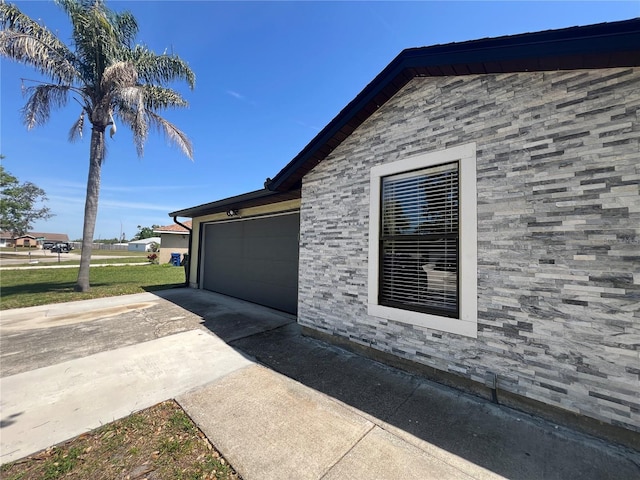 view of side of property with a lawn, driveway, and an attached garage