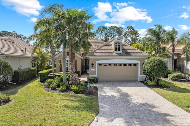 11716 Strandhill Ct, Lakewood Ranch, FL 34202 - view of front of property featuring a tiled roof, decorative driveway, a garage, a front lawn, and stucco siding