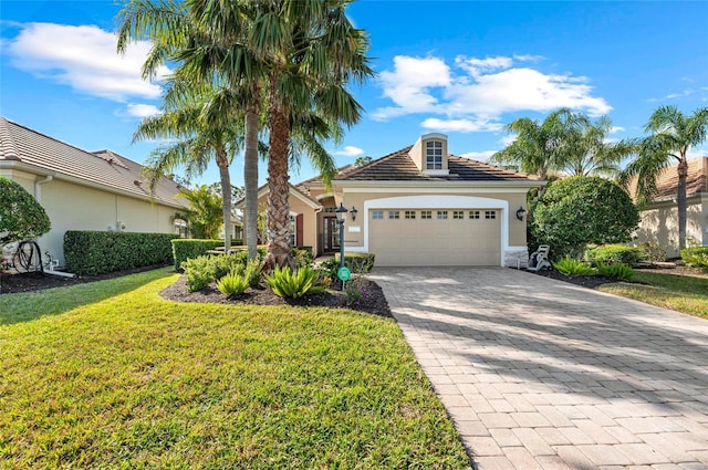 11716 Strandhill Ct, Lakewood Ranch, FL 34202 - view of front of home with decorative driveway, an attached garage, a tile roof, a front lawn, and stucco siding