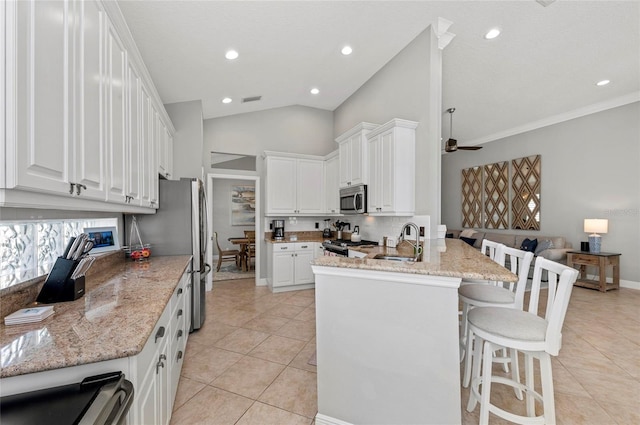 11716 Strandhill Ct, Lakewood Ranch, FL 34202 - kitchen with a sink, a kitchen breakfast bar, appliances with stainless steel finishes, a peninsula, and light tile patterned floors