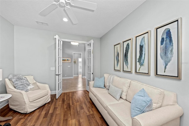 11716 Strandhill Ct, Lakewood Ranch, FL 34202 - living room featuring a textured ceiling, baseboards, wood finished floors, a ceiling fan, and french doors