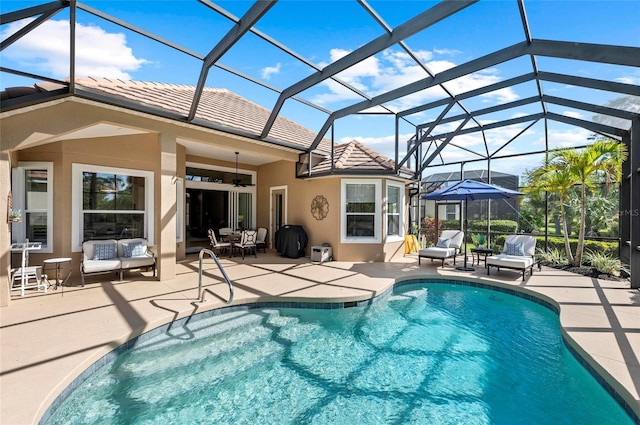 11716 Strandhill Ct, Lakewood Ranch, FL 34202 - pool with an outdoor hangout area, glass enclosure, ceiling fan, a grill, and a patio area