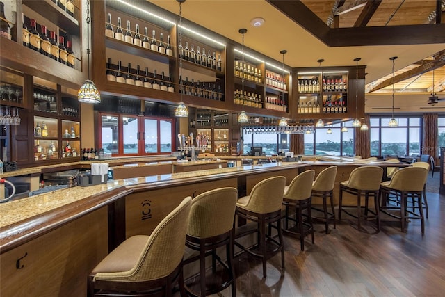 11716 Strandhill Ct, Lakewood Ranch, FL 34202 - bar featuring a community bar, a high ceiling, wood finished floors, and pendant lighting