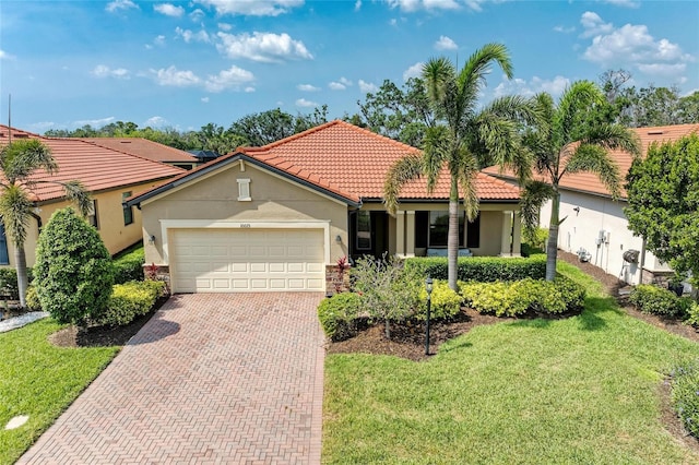 10015 Marbella Dr, Bradenton, FL 34211 - mediterranean / spanish home featuring stucco siding, a garage, decorative driveway, a front yard, and a tile roof