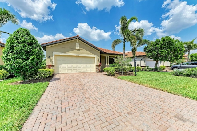 10015 Marbella Dr, Bradenton, FL 34211 - ranch-style home featuring stucco siding, decorative driveway, a front lawn, a garage, and stone siding