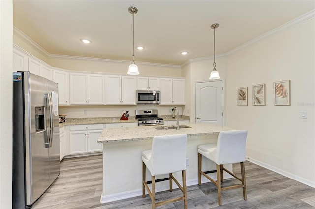 10015 Marbella Dr, Bradenton, FL 34211 - kitchen with appliances with stainless steel finishes, crown molding, white cabinetry, light wood-style floors, and a kitchen breakfast bar