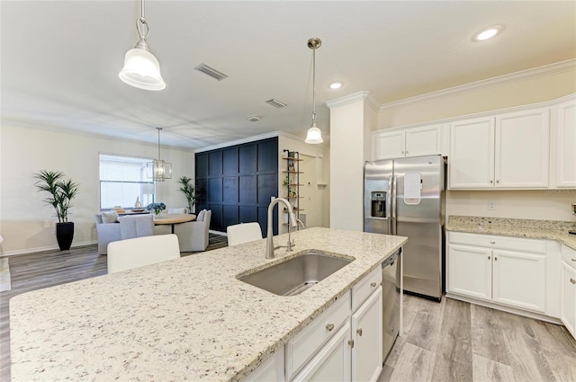 10015 Marbella Dr, Bradenton, FL 34211 - kitchen with appliances with stainless steel finishes, crown molding, light wood-style flooring, white cabinets, and light stone countertops