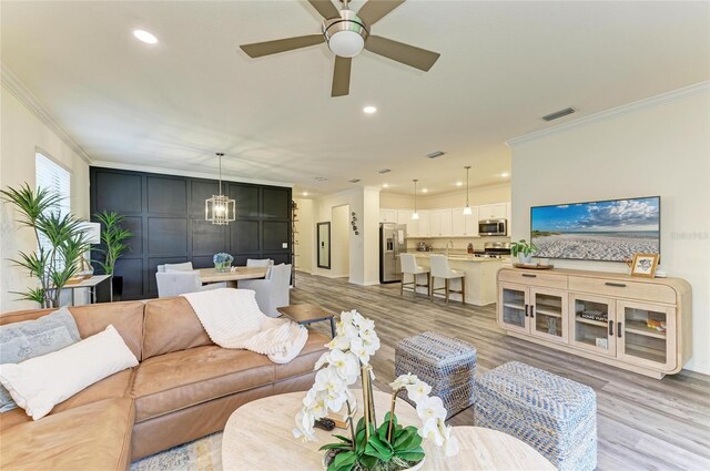 10015 Marbella Dr, Bradenton, FL 34211 - living room featuring crown molding, light wood-type flooring, a ceiling fan, and recessed lighting