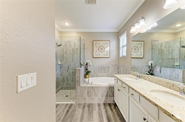 10015 Marbella Dr, Bradenton, FL 34211 - bathroom with wood finished floors, a garden tub, double vanity, a shower stall, and crown molding