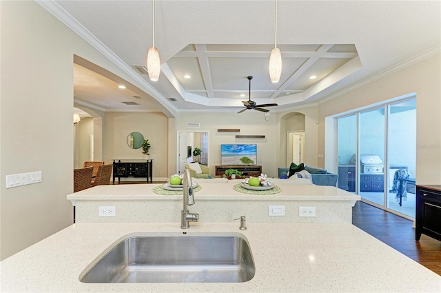 7278 Lismore Ct, Lakewood Ranch, FL 34202 - kitchen featuring arched walkways, a sink, coffered ceiling, crown molding, and dark wood finished floors