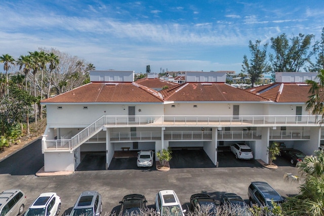 5055 Gulf Of Mexico Dr Unit 422, Longboat Key, FL 34228 - back of house featuring covered parking, a tile roof, and stucco siding